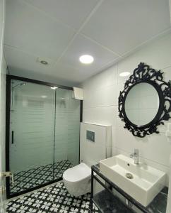 y baño con aseo, lavabo y espejo. en Cunda Kordon Otel, en Ayvalık