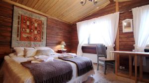 a bedroom with a bed and a desk and a window at Hotel Taivaanvalkeat in Köngäs