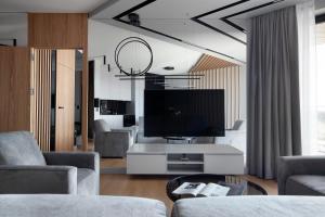 ein Wohnzimmer mit einem Sofa und einem TV in der Unterkunft Elite Apartments Tarasy Bałtyku in Danzig