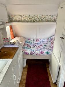 a small room with a bed in a kitchen at Cosy Caravan at Carrigeen Glamping in Kilkenny