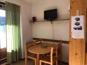 a dining room with a table and chairs and a tv at Appartement Villard-de-Lans, 2 pièces, 5 personnes - FR-1-515-45 in Villard-de-Lans