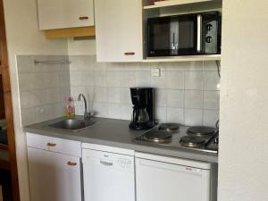 a kitchen with a stove and a sink and a microwave at Appartement Villard-de-Lans, 2 pièces, 5 personnes - FR-1-515-45 in Villard-de-Lans