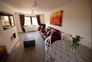 a living room with a couch and a table at Annie's Corner - Fort William in Caol