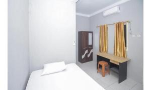 BitungLidez Residence Bitung的一间带床和书桌的白色卧室 更多16张照片