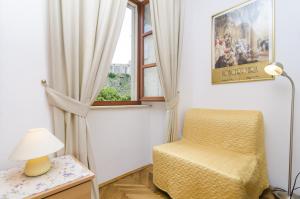 una silla y una lámpara en una habitación con ventana en Rooms Lovrijenac, en Dubrovnik