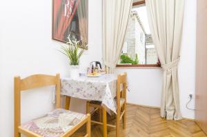 a small table and chairs in a room with a window at Rooms Lovrijenac in Dubrovnik