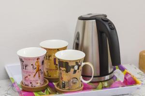 una macchinetta del caffè e 3 tazze di caffè su un vassoio di Rooms Lovrijenac a Dubrovnik Altre 38 foto