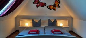 una camera da letto con farfalle sul muro e un letto di Ferienwohnung Wikingerland a Langballig