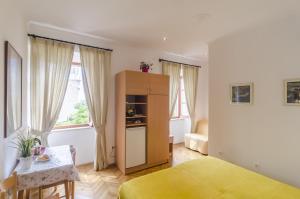 a bedroom with a bed and a cabinet and a table at Rooms Lovrijenac in Dubrovnik