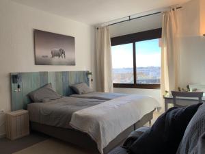 a bedroom with a large bed and a large window at Apartamentos RG Resitur in Seville