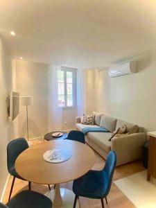 een woonkamer met een tafel en een bank bij Le Palm Appartement élégant & Design En Bord Rivière in Collobrières