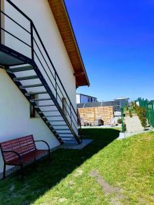 a bench sitting next to a building with a staircase at Apartament przy Brzozowej Polanie in Perlino +17 photos