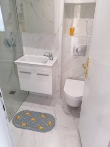 a white bathroom with a sink and a toilet at Kassandros Studios - Hanioti Halkidiki in Hanioti