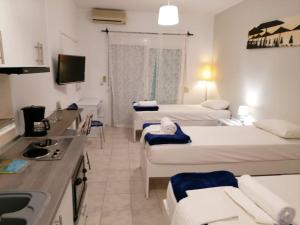 a hotel room with two beds and a kitchen at Kassandros Studios - Hanioti Halkidiki in Hanioti