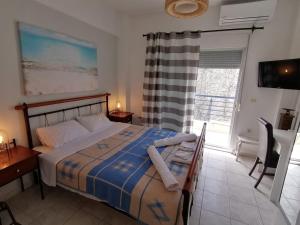 a bedroom with a bed and a desk and a window at Kassandros Studios - Hanioti Halkidiki in Hanioti