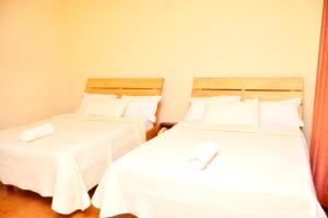 2 Betten nebeneinander in einem Zimmer in der Unterkunft Musanto Hotel in Gisenyi