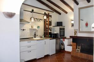a kitchen with white cabinets and a fireplace at A nossa Estrela in Moura