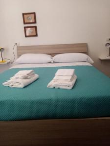 a bed with two folded towels on top of it at Mamena in Paestum