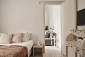 ein weißes Schlafzimmer mit einem Bett und einem Spiegel in der Unterkunft Casa Bo Private Pool in Mykonos Stadt
