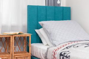 1 cama con cabecero azul y almohada blanca en Seaside Apartment Gdynia Redłowo by Renters en Gdynia