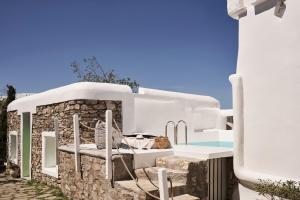 ein weißes Gebäude mit einer Bank und einem Pool in der Unterkunft Casa Bo Private Pool in Mykonos Stadt