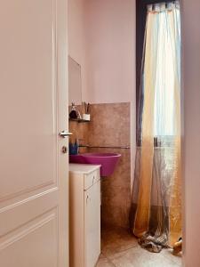 La salle de bains est pourvue d'un lavabo rose et d'un lavabo violet. dans l'établissement Sicilia Vacation, à Trapani