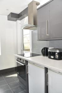 uma cozinha com armários brancos e uma bancada em Bright and spacious 2 bedroom apartment em Sutton