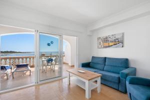 Una sala de estar con un sofá azul y una mesa. en Punta Prima Apartments, en Punta Prima