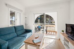 Una sala de estar con un sofá azul y una mesa. en Punta Prima Apartments, en Punta Prima