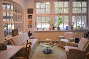 a living room with chairs and a table and windows at Waldwerk Wurlgrund Lychen in Lychen