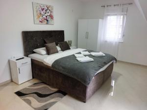 a bedroom with a large bed with two towels on it at Apartmani Marija in Vrdnik