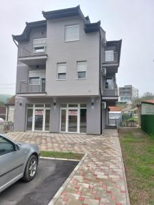 a house with a car parked in front of it at Apartmani Marija in Vrdnik