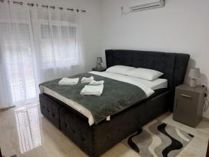 a bedroom with a large bed with towels on it at Apartmani Marija in Vrdnik
