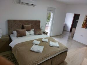 a bedroom with a large bed with towels on it at Apartmani Marija in Vrdnik