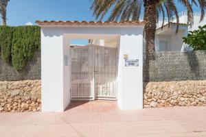 a white door with a gate in front of a fence at NEW! Apartment ONA 1 with Pool, AC, BBQ, Wifi in Cala D'or, Mallorca in Cala D'or