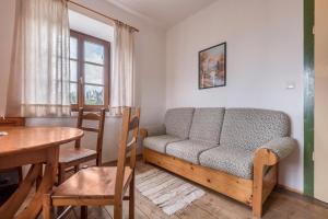- un salon avec un canapé et une table dans l'établissement Sallrain Hof Apartment 2, à Collalbo