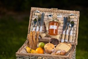 a basket filled with bread and fruit and a jar of honey at Mirabilia Boutique Hotel in Kriopigi