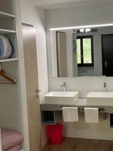 uma casa de banho com 2 lavatórios e um espelho em Osteria Posse em Lavertezzo