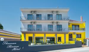 a yellow and white building with a sign in front of it at Thassian Riviera Hotel in Skala Prinou