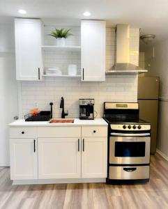 a kitchen with white cabinets and a stove at Sparkling Guest Home 2 bedroom-15 Minutes to Clearwater Beach in Clearwater