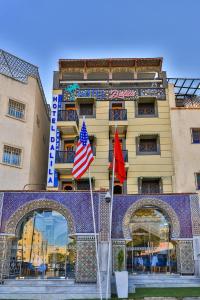 a hotel with two flags in front of it at Hotel & Ryad DALILA in Fès