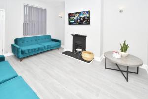 a living room with a blue couch and a fireplace at Heathfield House by YourStays in Crewe