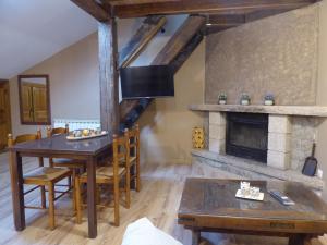 a dining room with a table and a fireplace at Hotel Rural La Casa de Irene in Lubián