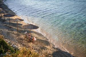 a group of umbrellas and chairs on a beach at Mirabilia Boutique Hotel in Kriopigi