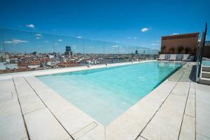 a swimming pool on the roof of a building at SmartRental Collection Gran Vía Capital in Madrid