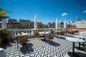 a patio with tables and chairs on a roof at SmartRental Collection Gran Vía Capital in Madrid