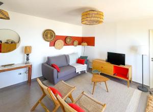 uma sala de estar com um sofá e uma televisão em Le Pétrel dans les Nuages - Appartement avec terrasse en plein ciel dominant Saint-Denis em Saint-Denis