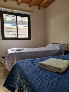 2 camas en una habitación con ventana en CASA TUNUYÁN en Tunuyán
