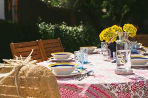 uma mesa com pratos e tigelas e um vaso em Villa La Jara Sanlúcar em Sanlúcar de Barrameda