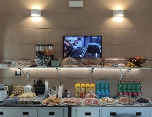 - un buffet avec des assiettes de nourriture et de boissons sur les étagères dans l'établissement Don Giovanni, à Alghero